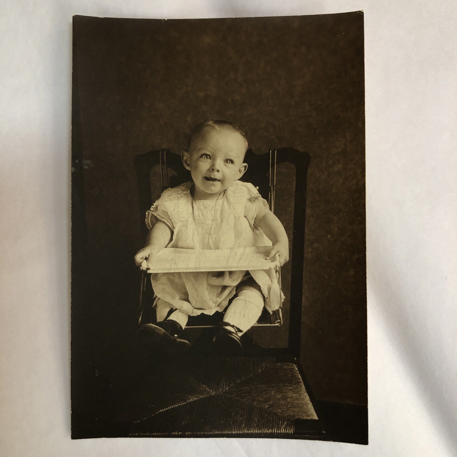 Real Photo 3-1/4 x 4-3/4" Baby Sitting in Baby Seat over Caned Chair 