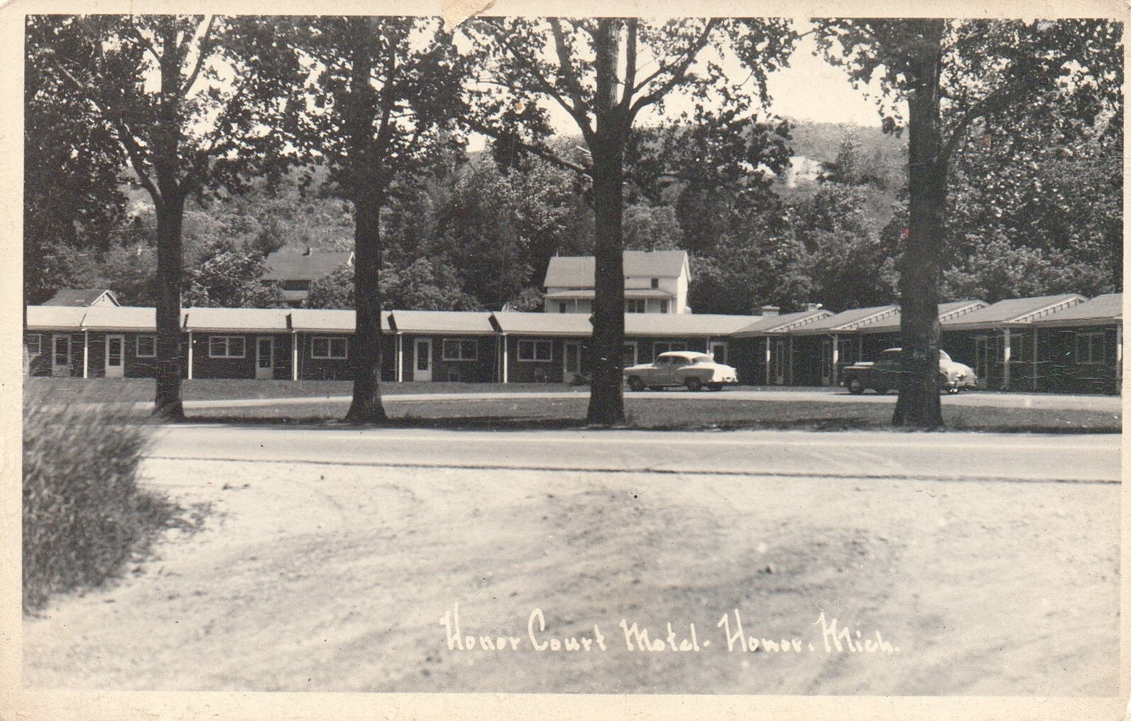 RPPC Honor Court Motel with Old Cars in Drive in Honor Michigan Postcard